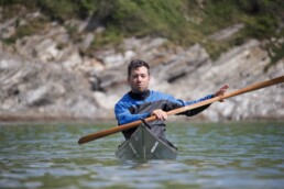 James Roberts Sea Kayak Coach Paddling a low volume Greenland Kayak on a Cornish Beach